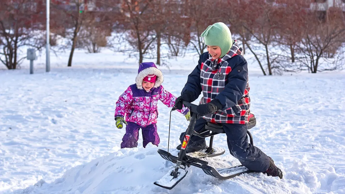 Barn som åker nedför en snöig backe